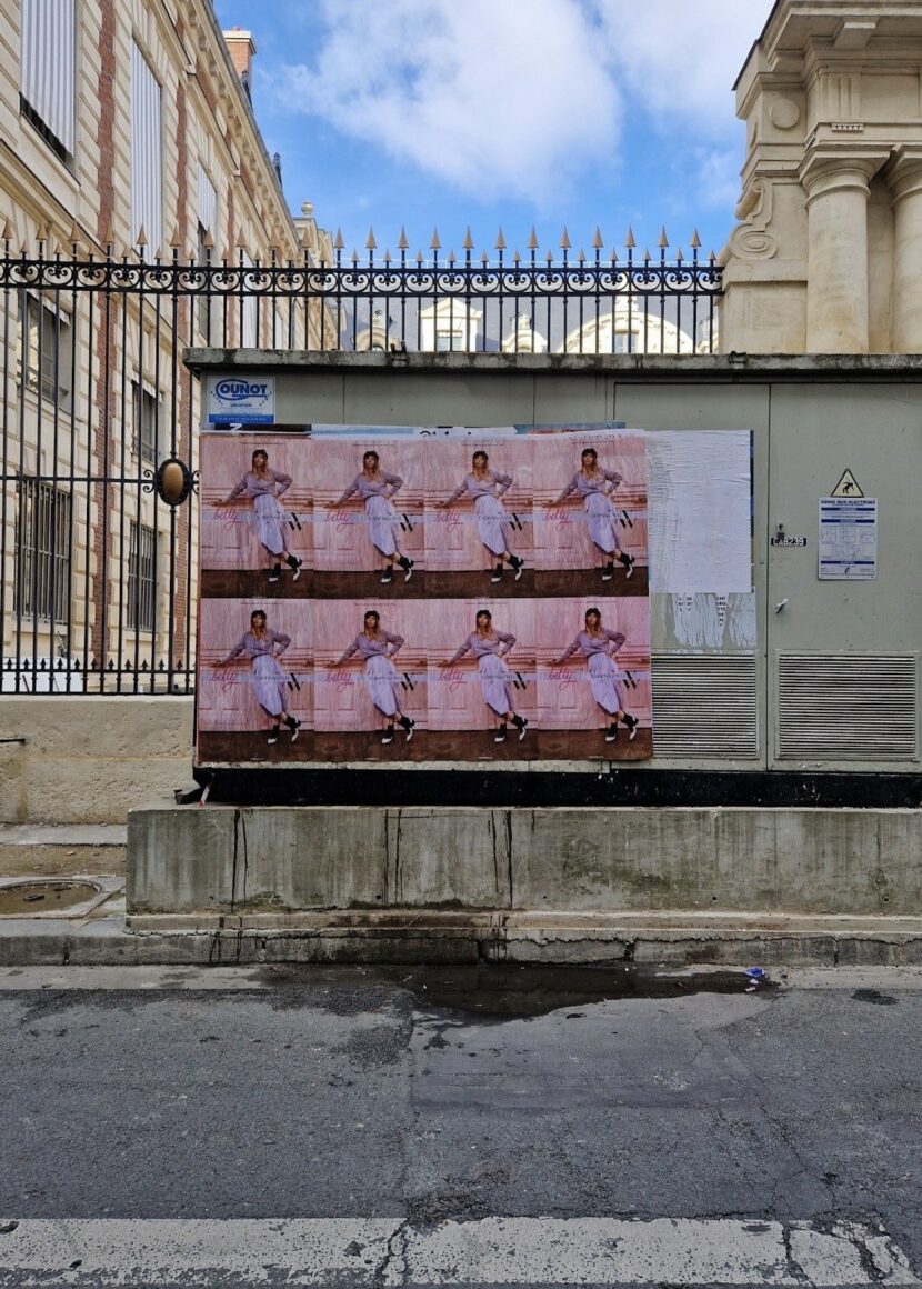 Mur d’affiches Betty x Vanessa Wu devant une grille parisienne
