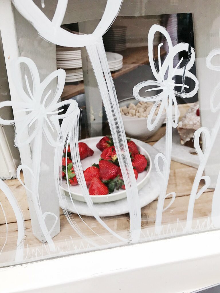 Fraises derrière une vitrine peinte de fleurs à Amsterdam