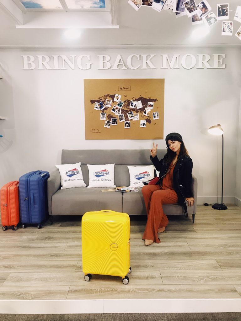 Betty Autier dans le salon Bring Back More d’American Tourister avec des valises colorées