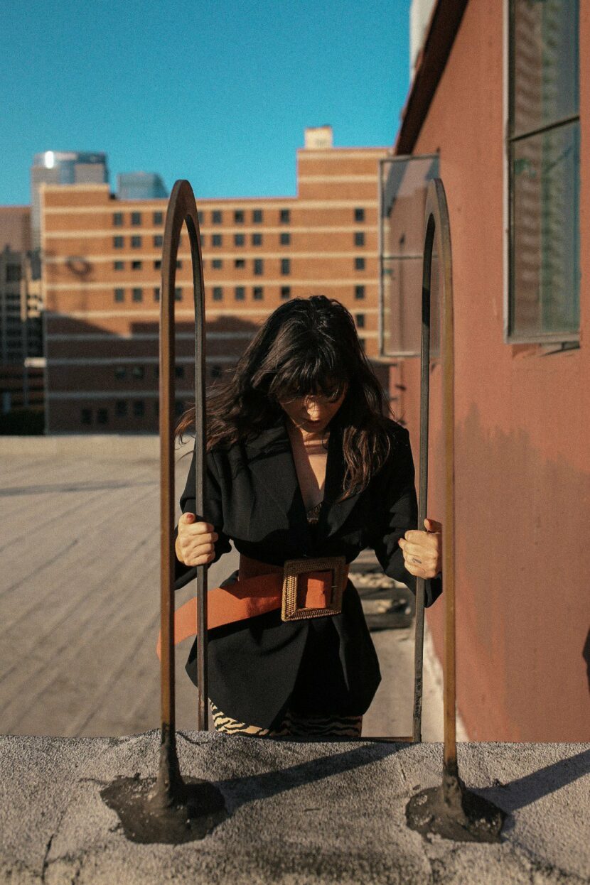 Betty Autier en blazer noir et grosse ceinture sur un rooftop de Downtown LA
