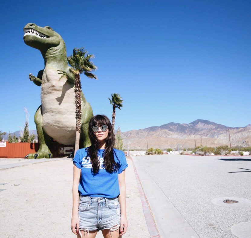 Betty Autier en t-shirt Dodgers devant les dinosaures de Cabazon