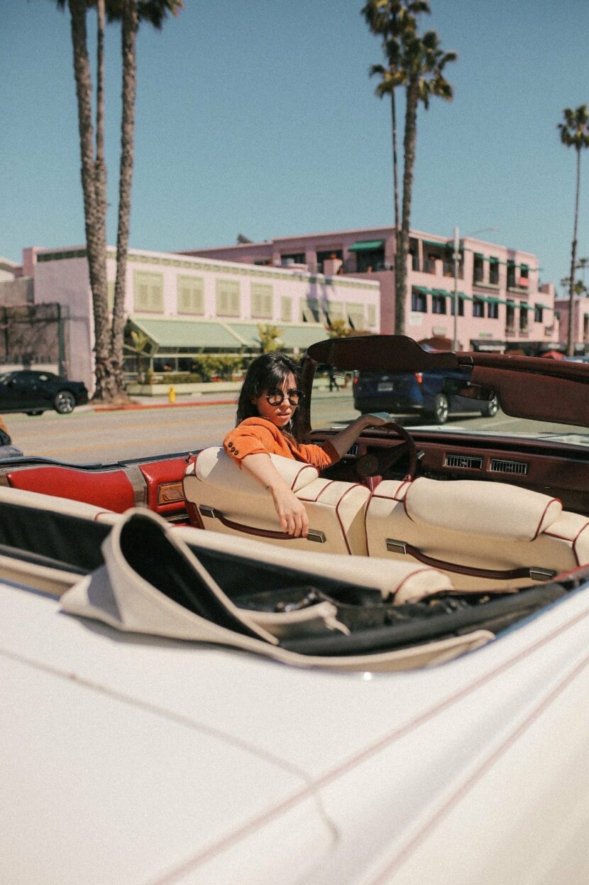 Betty Autier en Cadillac décapotable sous les palmiers de Los Angeles