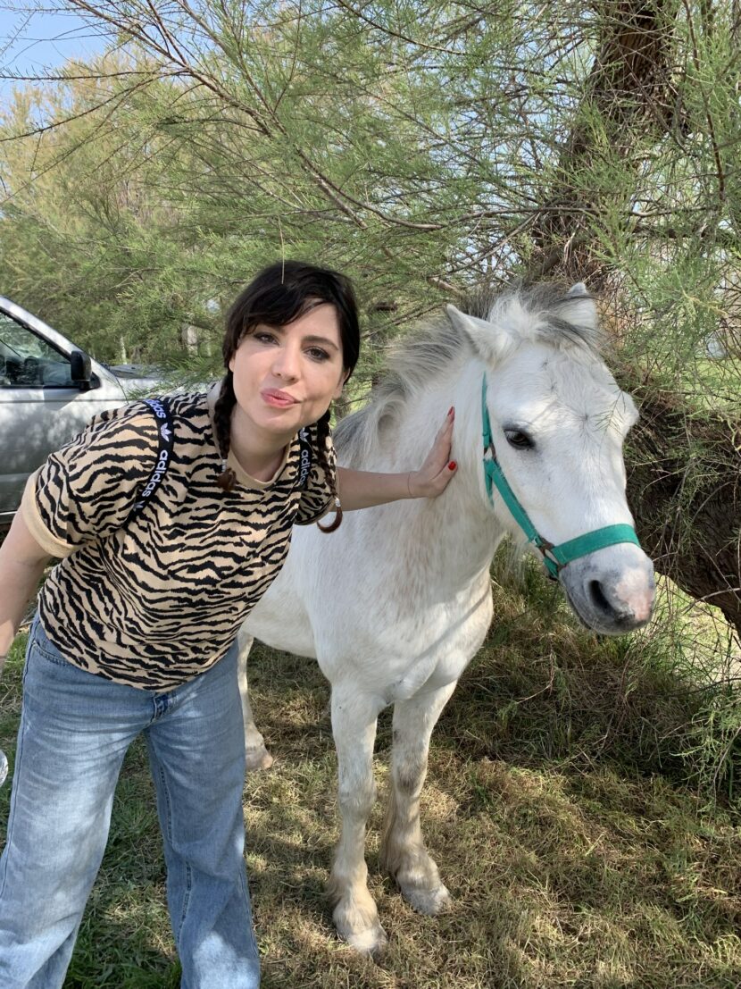 Betty Autier avec un cheval blanc de Camargue aux Saintes-Maries-de-la-Mer