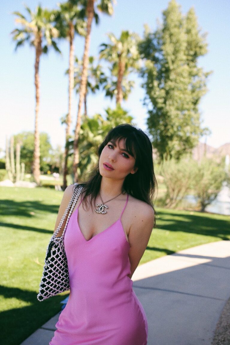 Betty Autier à Coachella en robe rose, collier Chanel et sac en perles