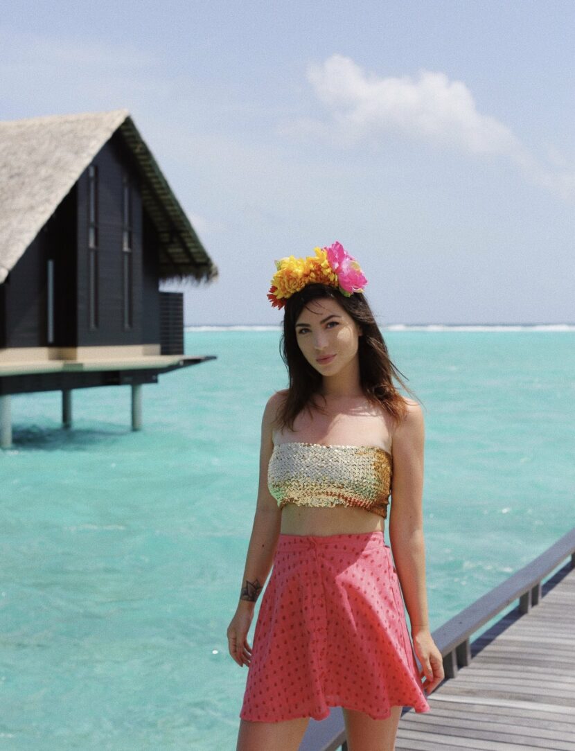 Betty Autier en couronne de fleurs et bandeau à sequins sur le ponton des water villas