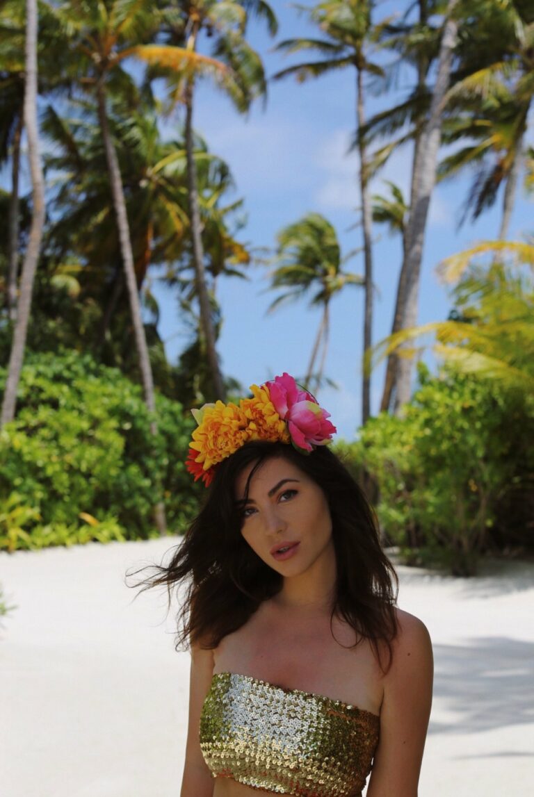Portrait de Betty Autier en couronne de fleurs sous les palmiers des Maldives