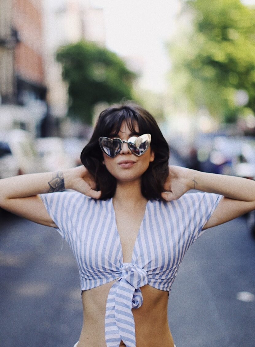 Betty Autier en crop top rayé et lunettes cœur dans une rue de New York