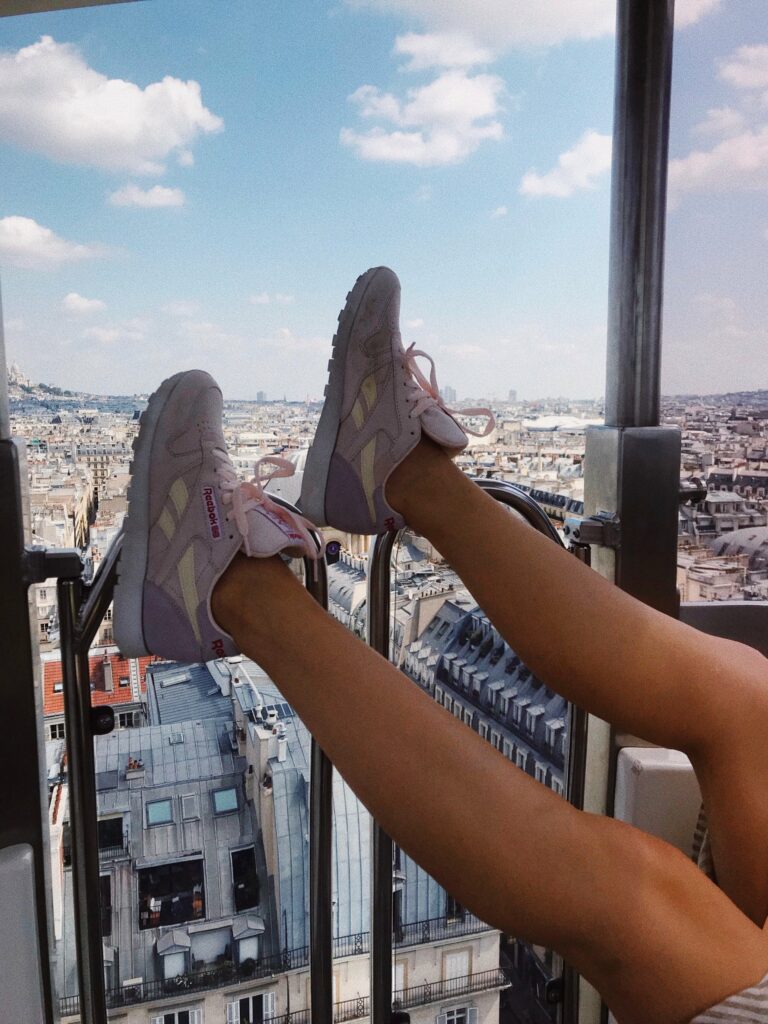 Baskets roses en l’air face au Sacré-Cœur depuis la grande roue