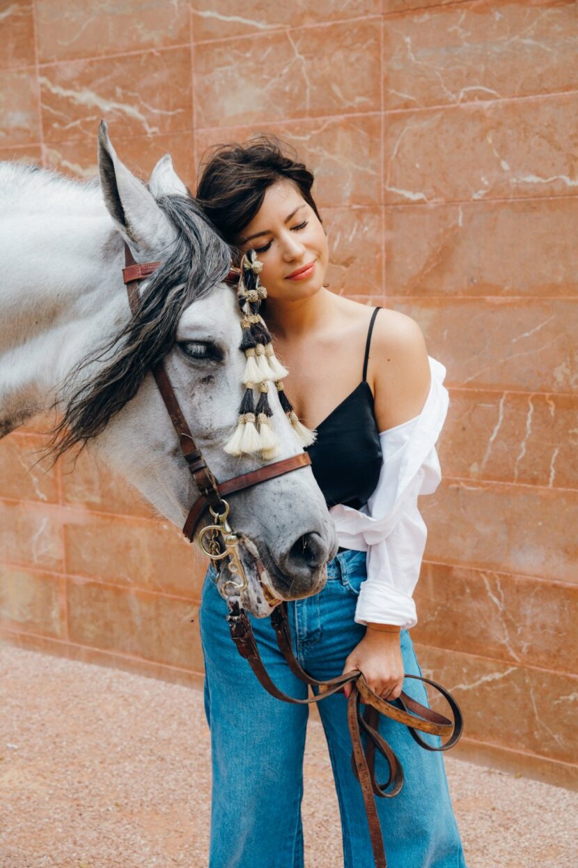 Betty Autier joue contre joue avec un cheval andalou