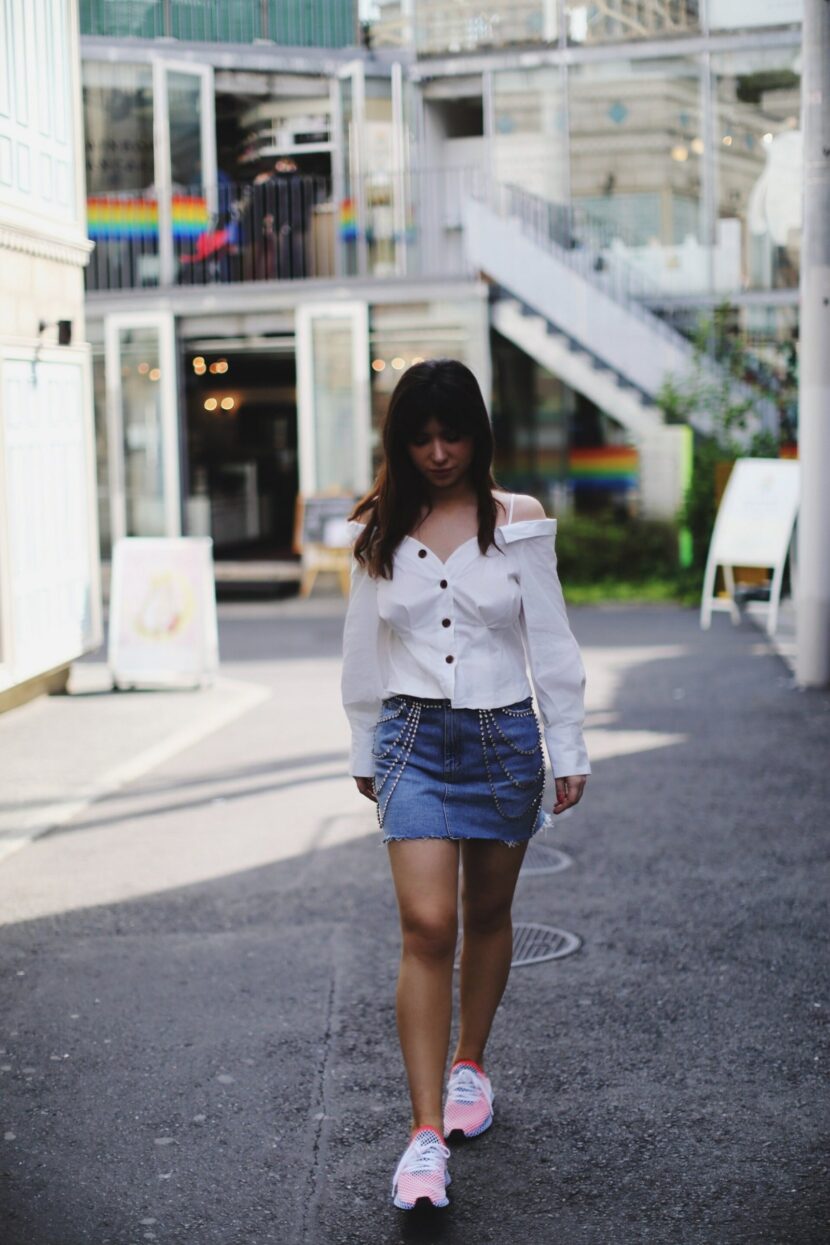 Betty Autier en jupe en jean à strass et Adidas Deerupt dans une rue de Harajuku