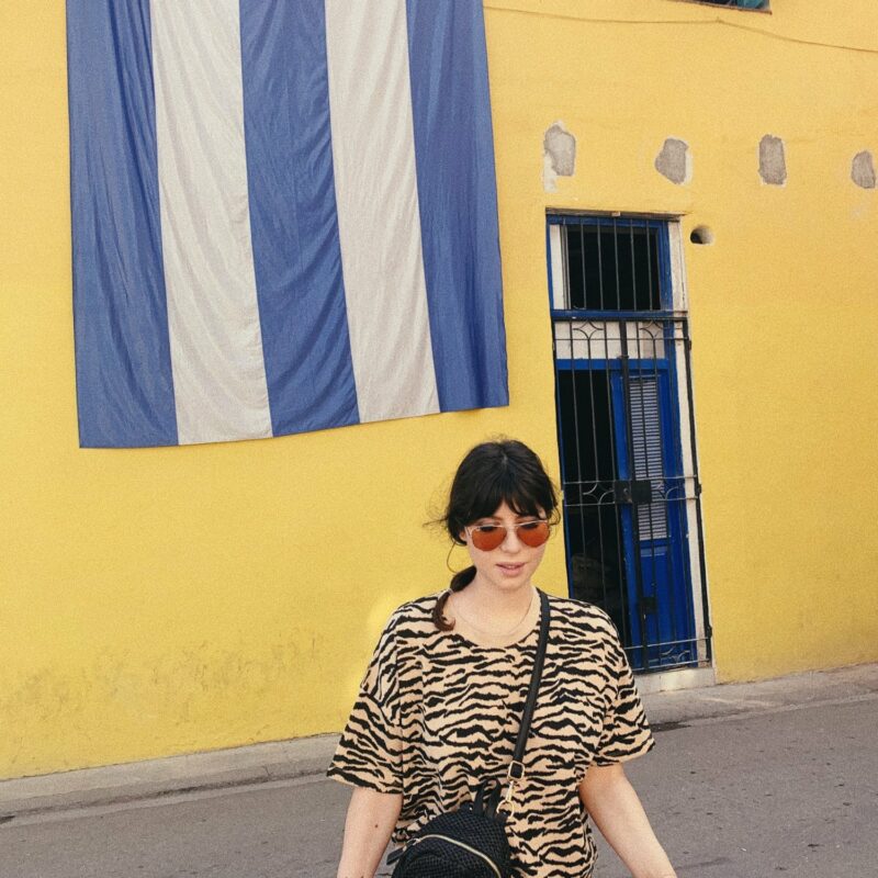 Betty Autier devant un drapeau cubain géant à La Havane, look imprimé tigre