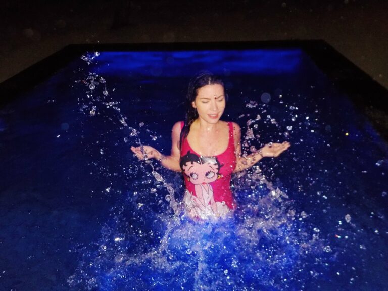 Betty Autier éclabousse dans la piscine de nuit en maillot Betty Boop Moschino