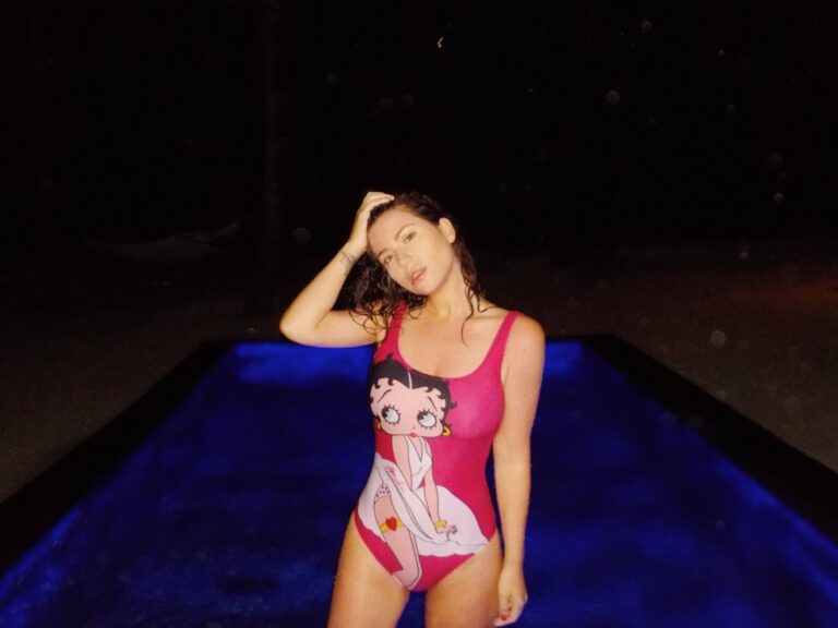 Betty Autier en maillot Betty Boop Moschino devant la piscine de sa villa la nuit