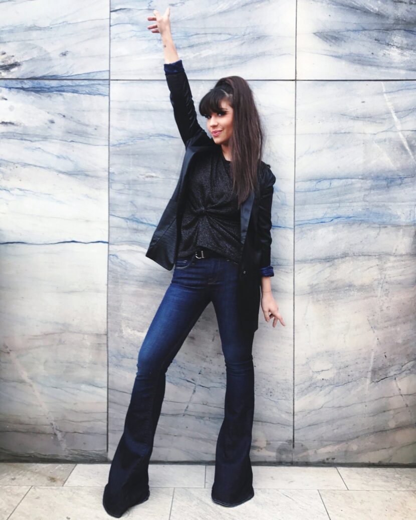 Betty Autier en jean flare et blazer devant un mur en marbre à Rotterdam