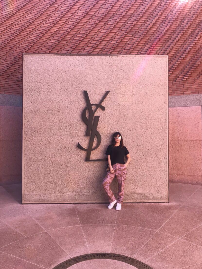 Betty Autier devant le logo YSL au musée Yves Saint Laurent de Marrakech