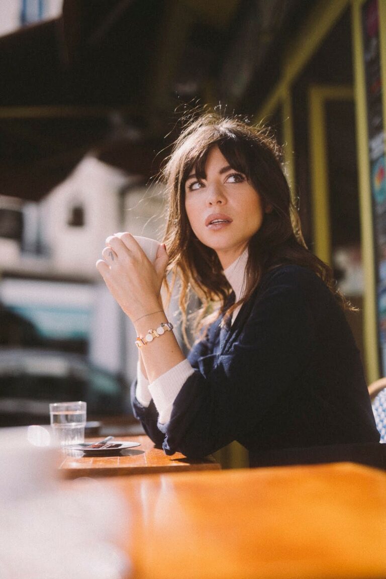 Betty Autier en terrasse de café avec ses bracelets Pandora Reflexions