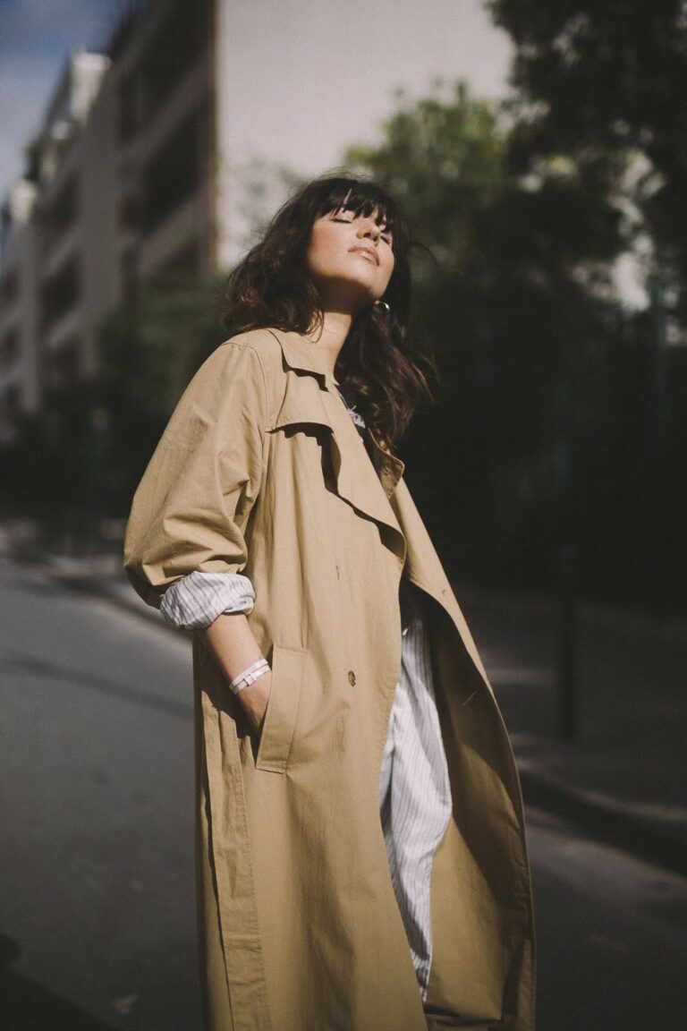 Betty Autier en trench beige, yeux fermés au soleil