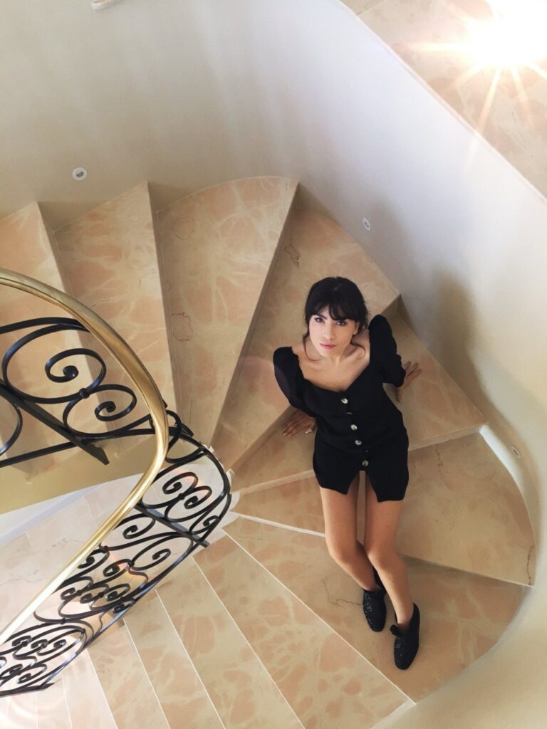 Betty Autier en robe noire dans un escalier en marbre