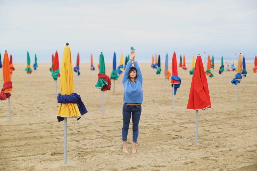 Betty Autier en pull bleu au milieu des parasols de la plage de Deauville
