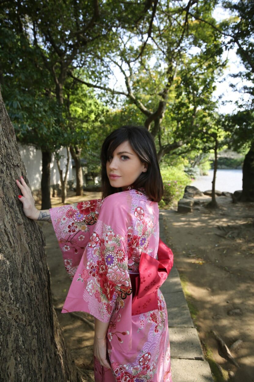 Portrait de Betty Autier en kimono rose contre un arbre à Kamakura