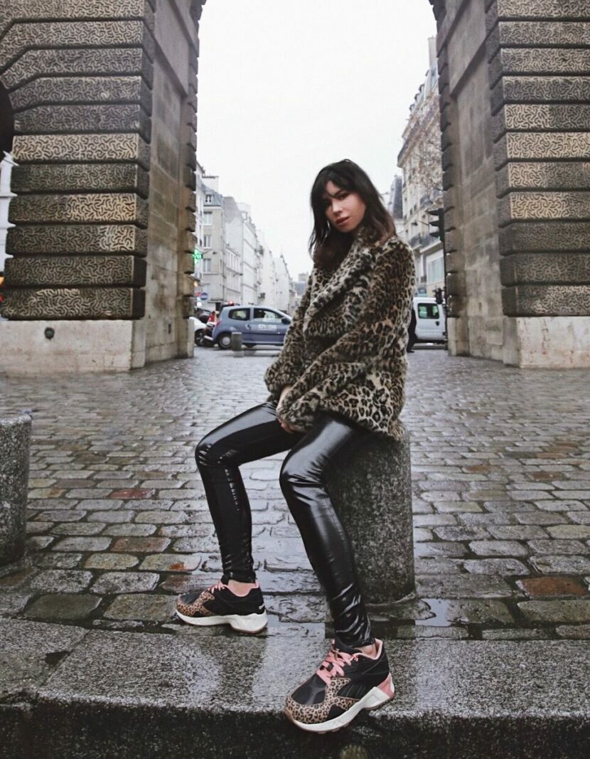 Betty Autier porte ses sneakers Reebok x Betty Autier Aztrek léopard à la Porte Saint-Denis