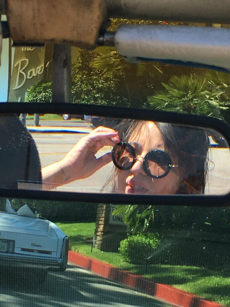 Betty Autier en lunettes rondes dans un rétroviseur