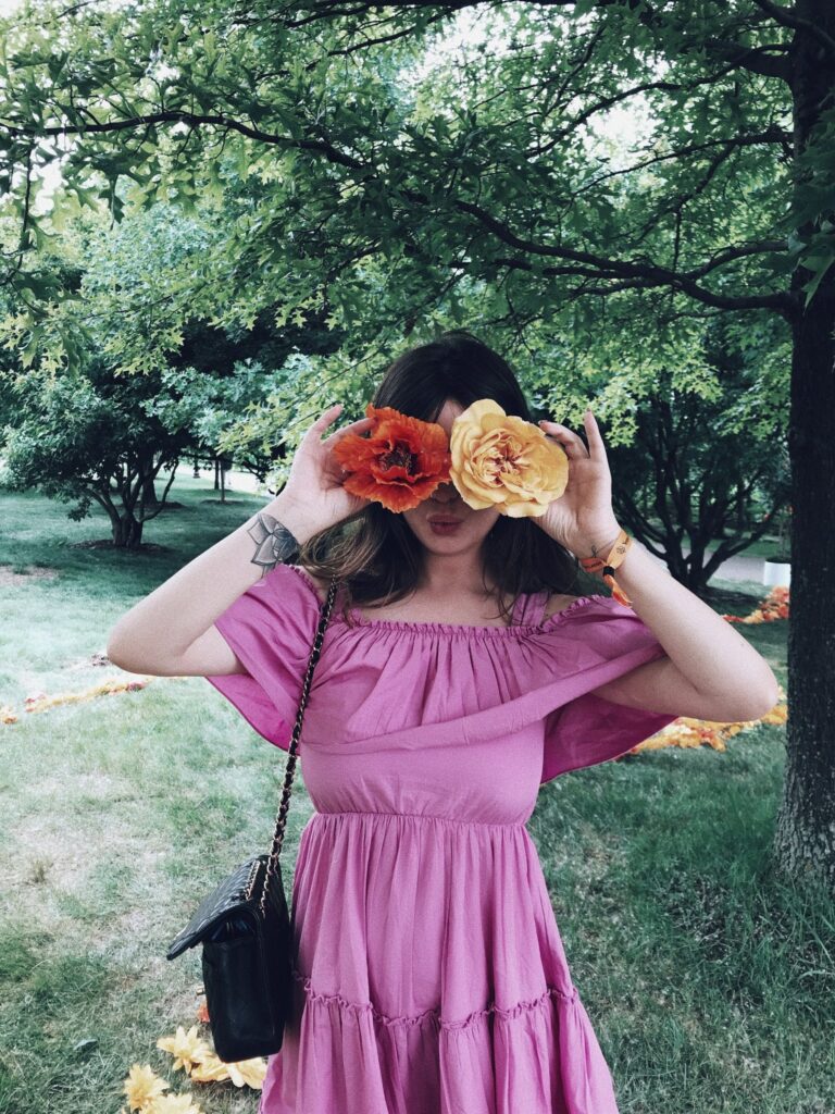 Betty Autier en robe rose, des fleurs devant les yeux au Polo Classic