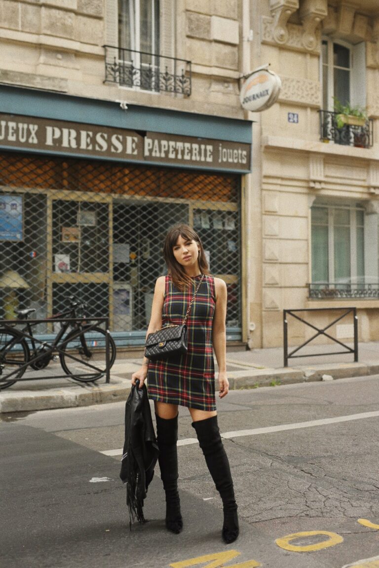 Betty Autier en robe tartan devant une papeterie parisienne