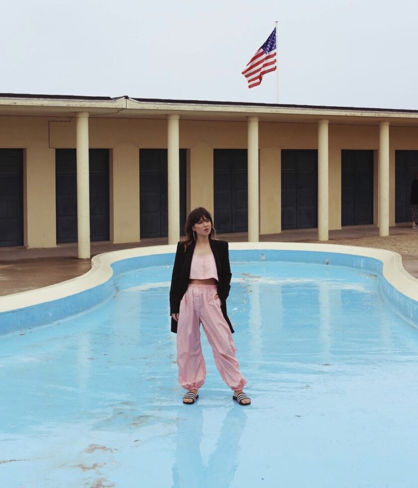 Betty Autier en sarouel rose Weekday et blazer noir devant le bassin de la plage de Deauville