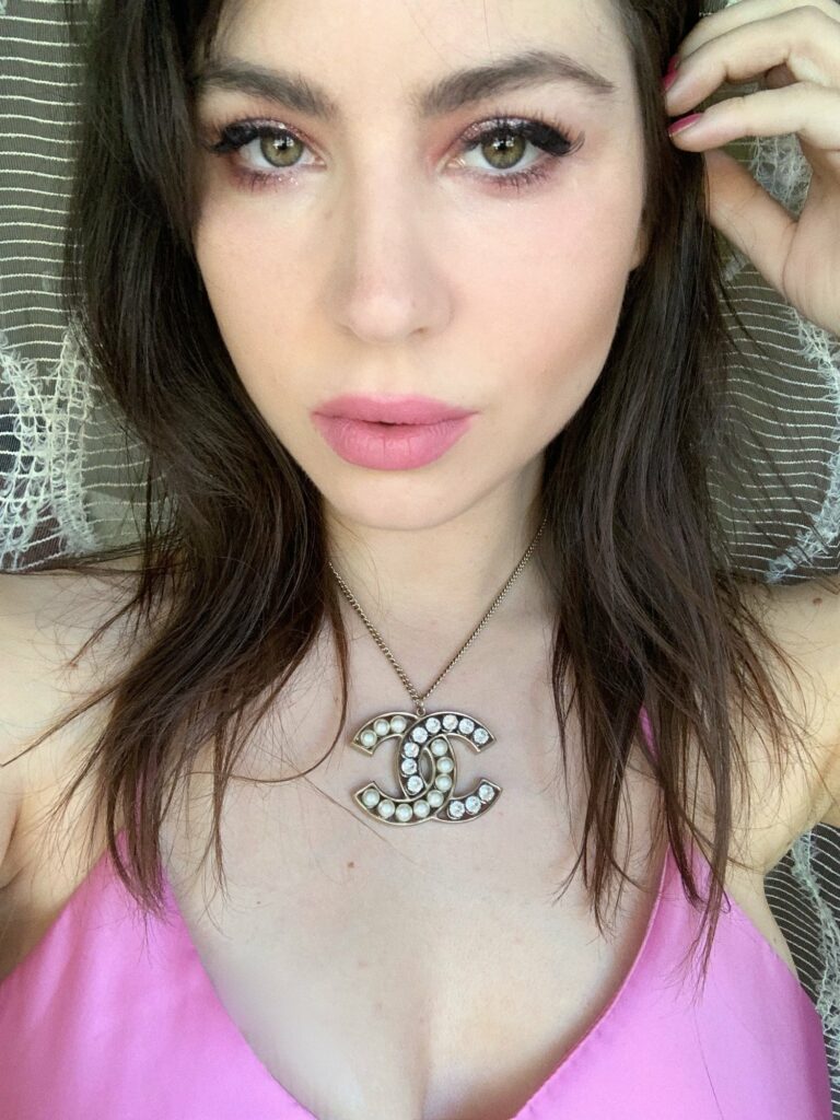 Selfie de Betty Autier avec un collier Chanel et un top rose
