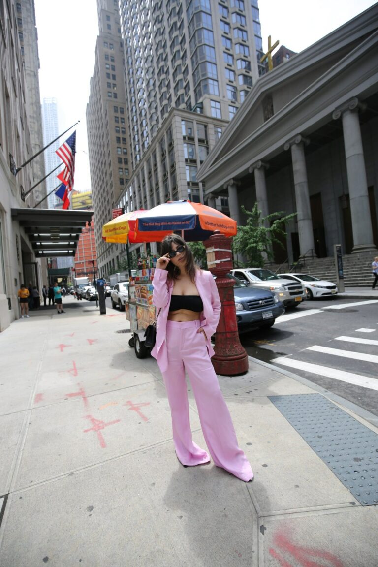 Betty Autier en tailleur rose devant un stand de hot dogs à New York