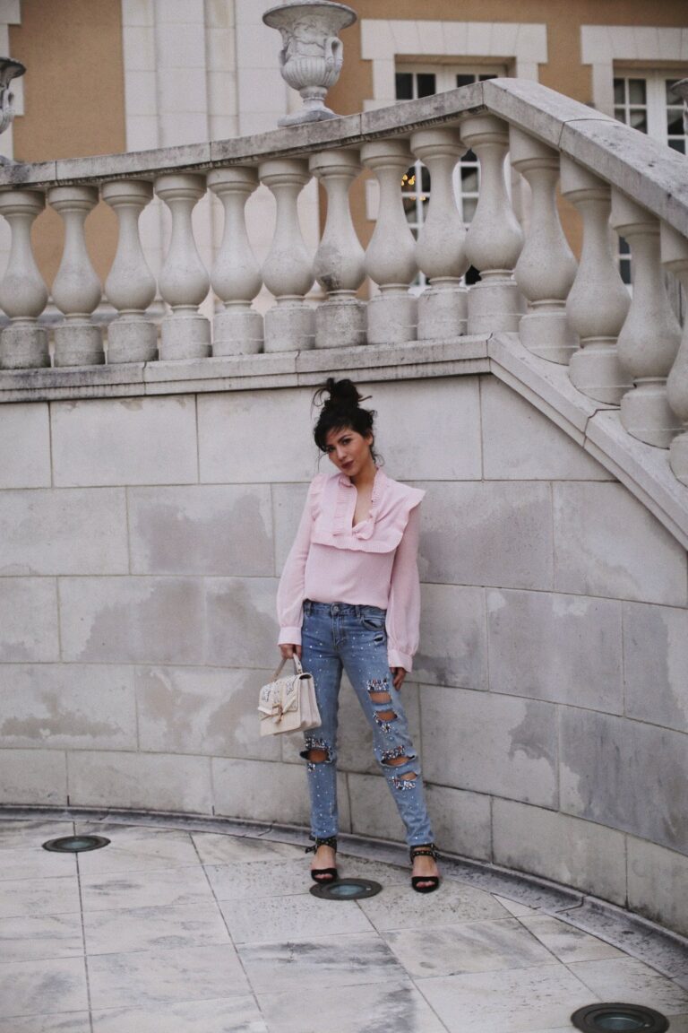 Betty Autier en blouse rose et jean à strass