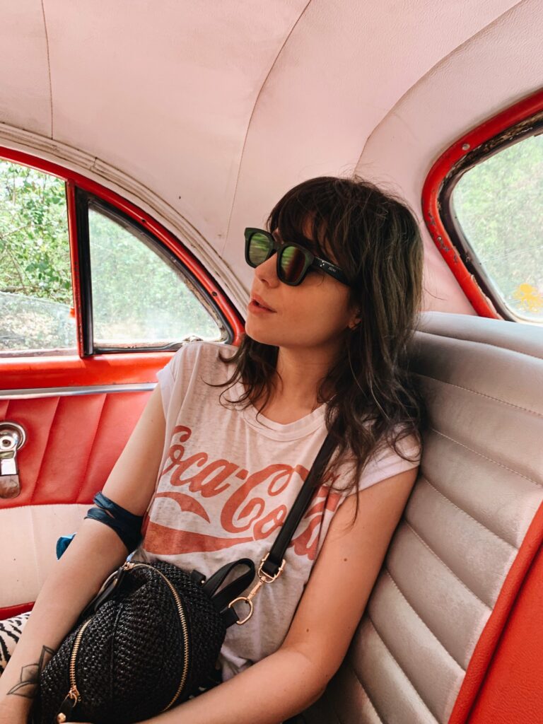 Betty Autier en t-shirt Coca-Cola dans une voiture américaine à Trinidad