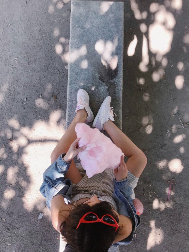 Betty Autier sur un banc avec sa barbe à papa, vue du dessus