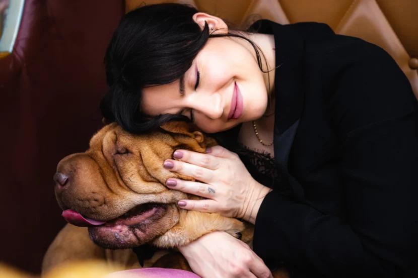 Betty Autier souriante avec un chien pour la campagne Betty x Bourjois
