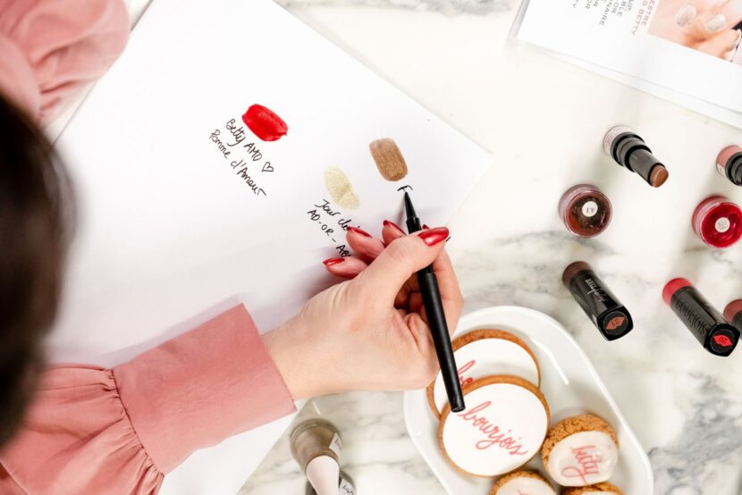 Betty Autier dessinant sur des macarons Bourjois pendant le workshop