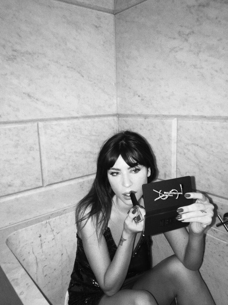Betty Autier se maquillant avec la pochette YSL, en noir et blanc