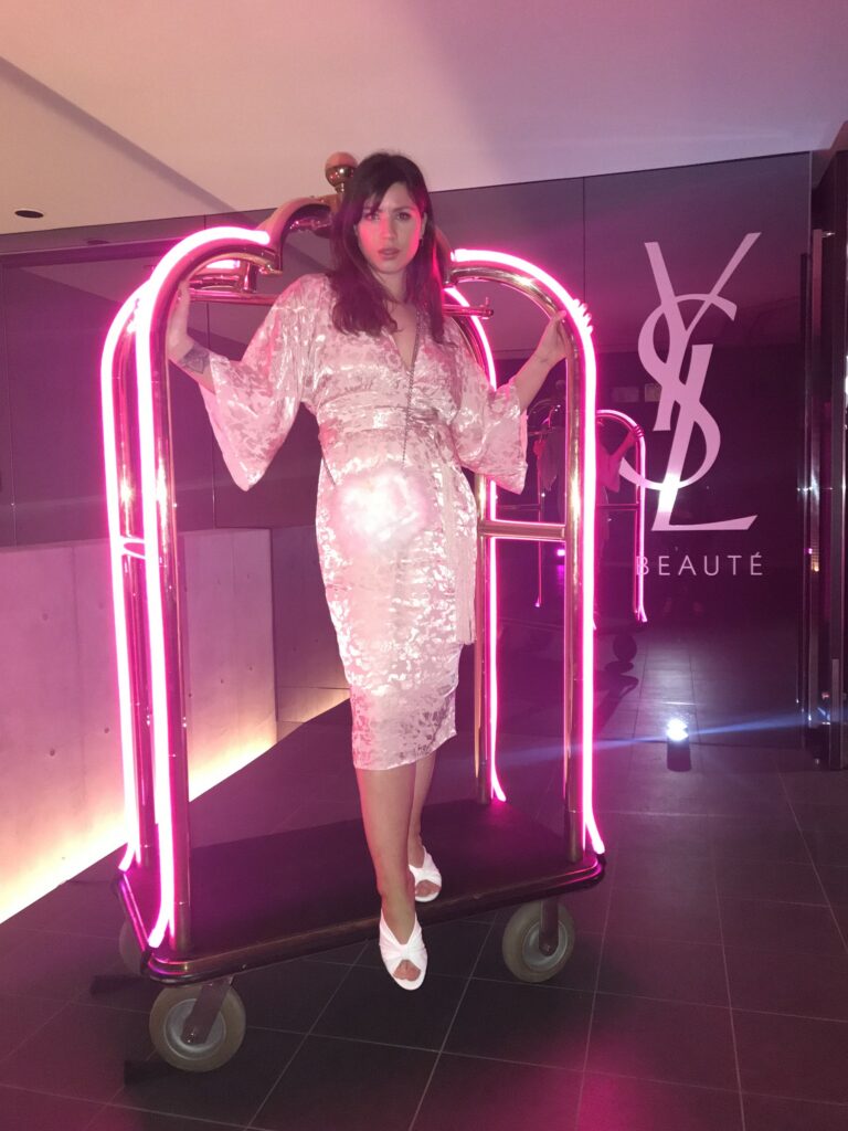 Betty Autier sur un chariot à bagages en néon rose au YSL Beauty Hotel Tokyo