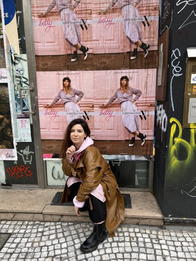 Betty Autier devant les affiches de la collection Betty x Vanessa Wu à Paris