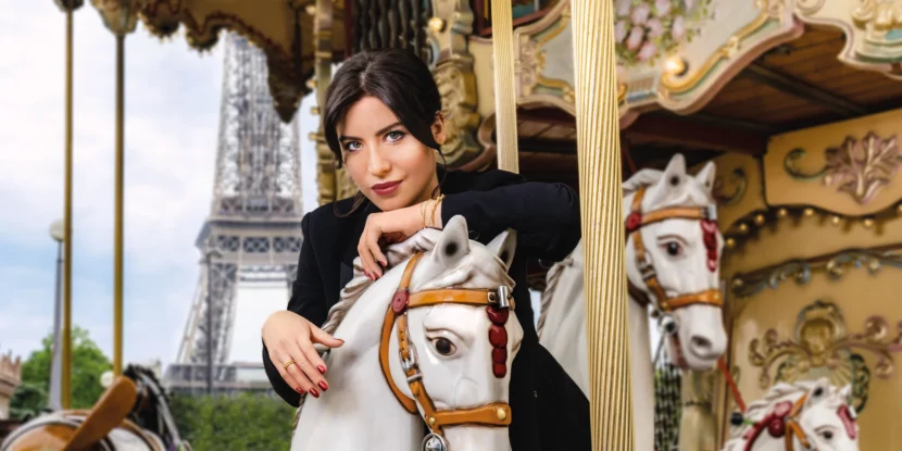 Betty Autier sur un cheval de carrousel devant la tour Eiffel, visuel de la collection Betty x Bourjois