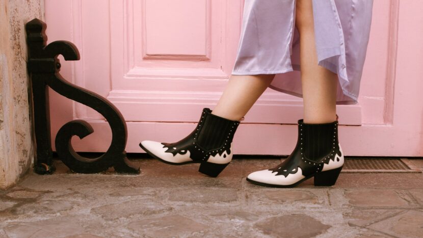 Bottines western noires et blanches Betty x Vanessa Wu devant une porte rose