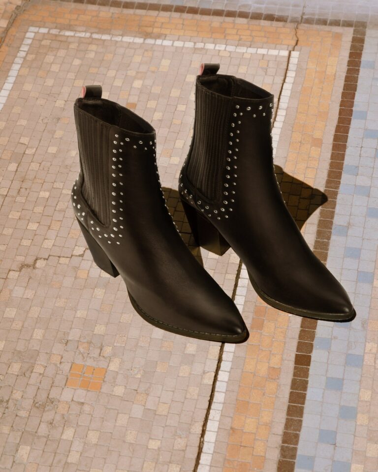 Bottines noires cloutées sur une mosaïque parisienne