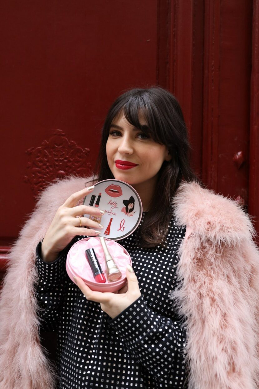 Betty Autier tenant le coffret en métal rose Betty x Bourjois édition limitée Noël