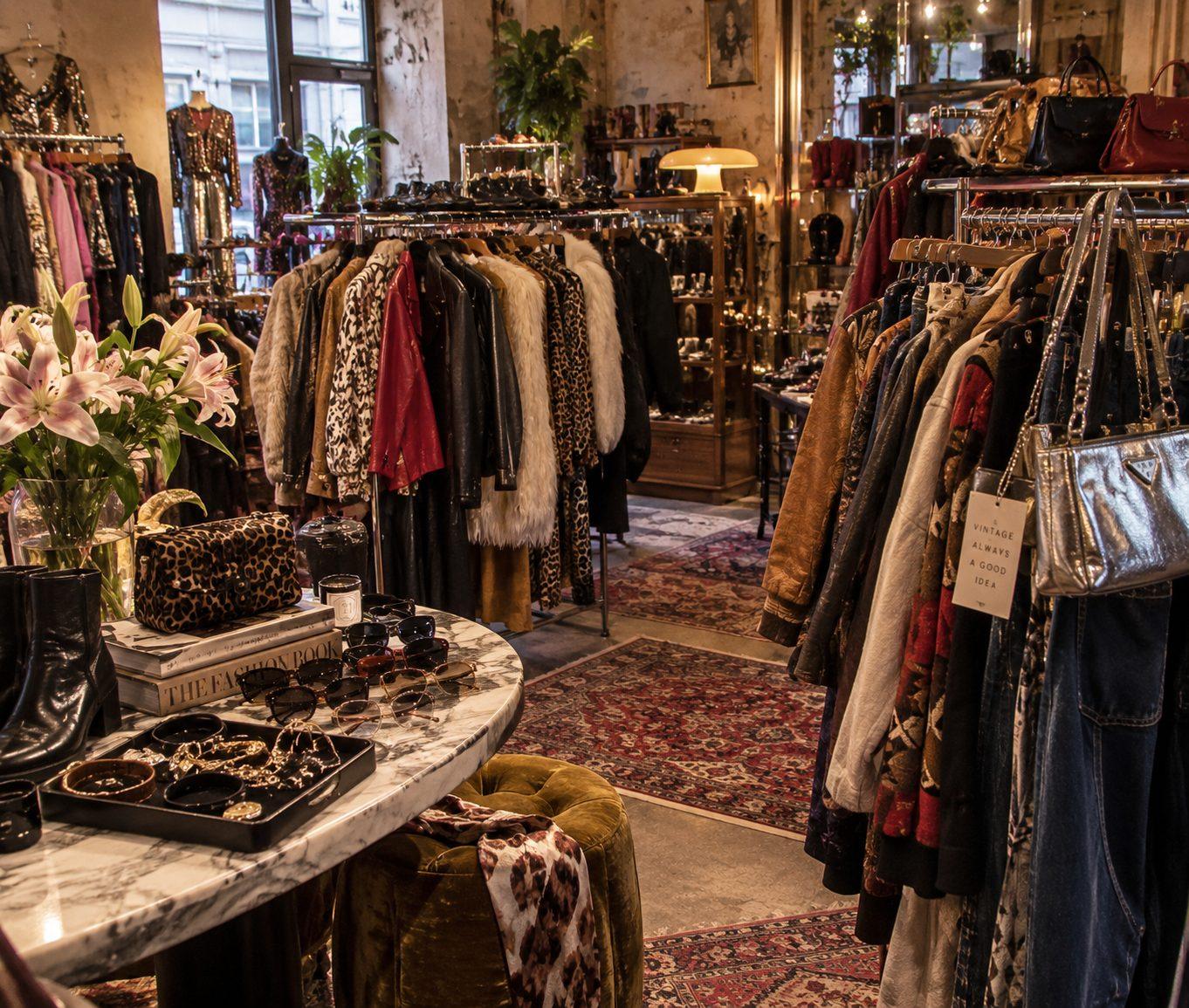Friperie vintage à Paris : portants de vestes en cuir, fourrures, sacs et lunettes