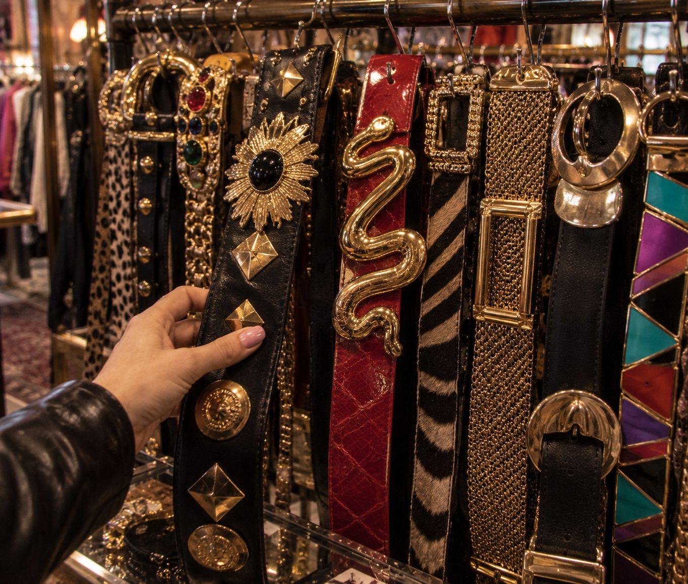 Ceintures vintage à boucles dorées, léopard, zèbre et serpent dans une friperie à Paris