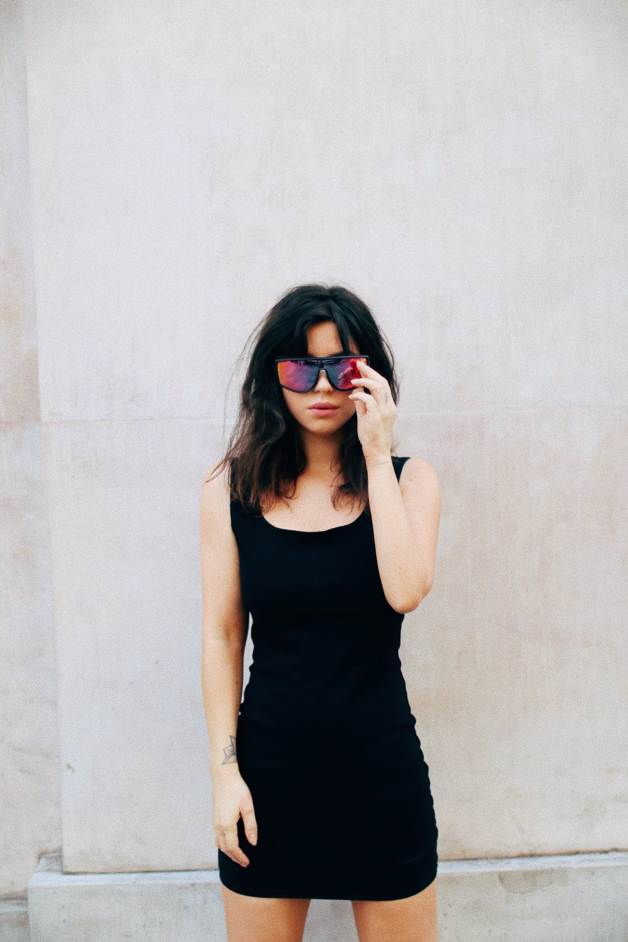 Betty Autier en robe noire moulante et lunettes miroir