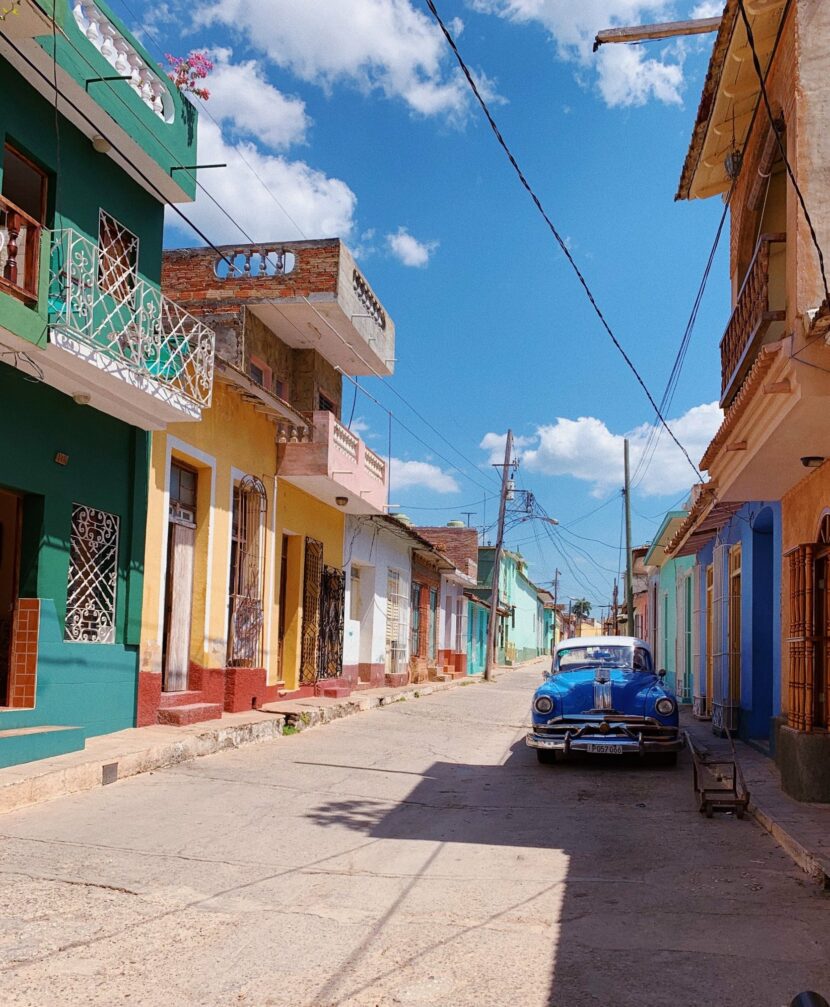 Rue colorée de Trinidad avec une voiture américaine bleue