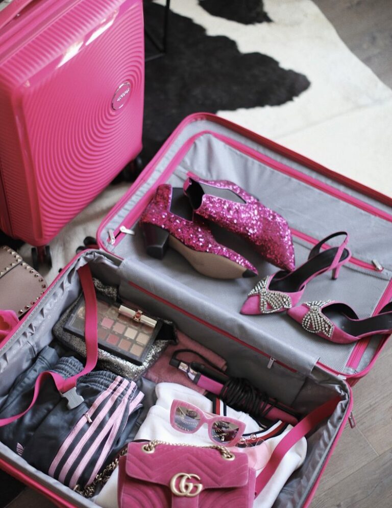 Valise rose American Tourister ouverte avec chaussures et accessoires roses