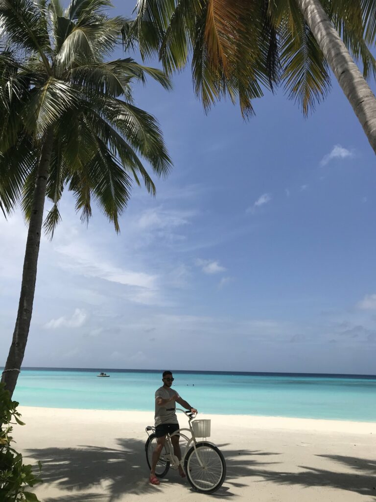 Vélo sur la plage bordée de palmiers du One&Only Reethi Rah